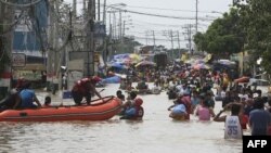 Cư dân lội qua khu vực ngập lụt tại thị trấn Calumpit, tỉnh Bulacan, phía bắc thủ đô Manila, Philippines, ngày 2/10/2011