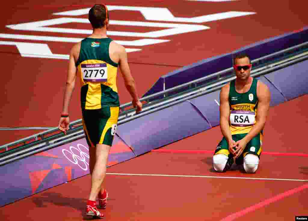 Hai tay điền kinh Oscar Pistorius (phải) v&agrave; Willem de Beer của Nam Phi, sau khi kh&ocirc;ng ho&agrave;n tất cuộc đua 400 m&eacute;t tiếp sức 4 người nam. 9/8/2012. REUTERS/David Gray