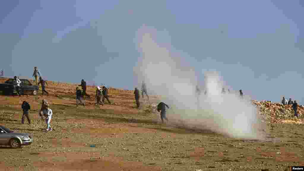 Binh sĩ Thổ Nhĩ Kỳ bắn hơi cay giải tán những người Kurd tụ tập xem trận chiến ở Kobani trên một ngọn đồi gần cửa khẩu Mursitpinar trên biên giới Thổ Nhĩ Kỳ-Syria, ngày 26/10/2014. &nbsp; 