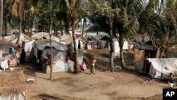 Người tị nạn Hồi giáo Rohingya đứng gần căn lều của họ trong trại tị nạn Awetawgyi ở Sittwe, bang Rakhine ở miền tây Miến Ðiện.