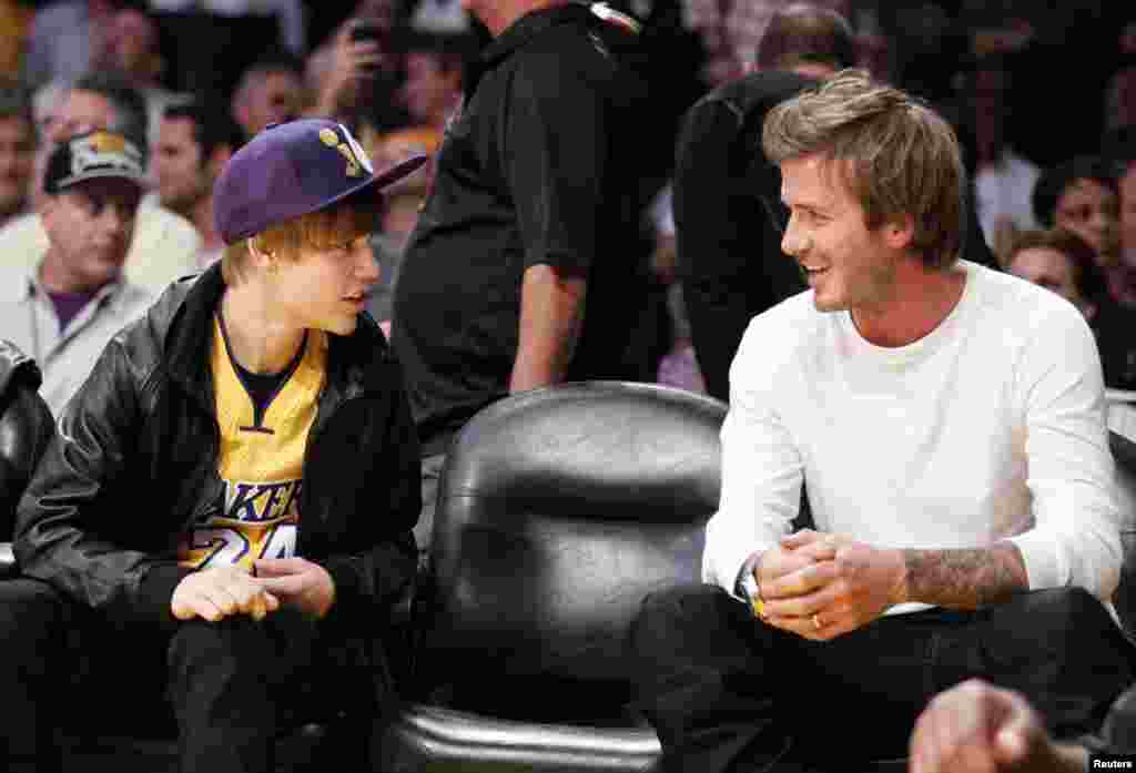 Ca sĩ Justin Bieber tr&ograve; chuyện với Beckham trong một trận đấu b&oacute;ng rổ nh&agrave; nghề Mỹ giữa 2 đội Los Angeles Lakers v&agrave; Houston Rockets ở Los Angeles, California, ng&agrave;y 26 th&aacute;ng 10, 2010.