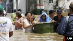 Cư dân tỉnh Bulacan, Philippines lội qua khu vực lụt lội vì bão Nalgae, ngày 3/10/2011