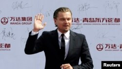 Diễn viên điện ảnh Leonardo DiCaprio chào giới truyền thông và các fan khi đến dự buổi lễ ở Thanh Đảo 22/9/13