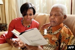 Đệ nhất phu nhân Hoa Kỳ Michelle Obama đến thăm cựu Tổng thống Nam Phi Nelson Mandela tại ngôi nhà của ông trong thành phố Houghton, 2011 (AP Photo/ Nelson Mandela Foundation)