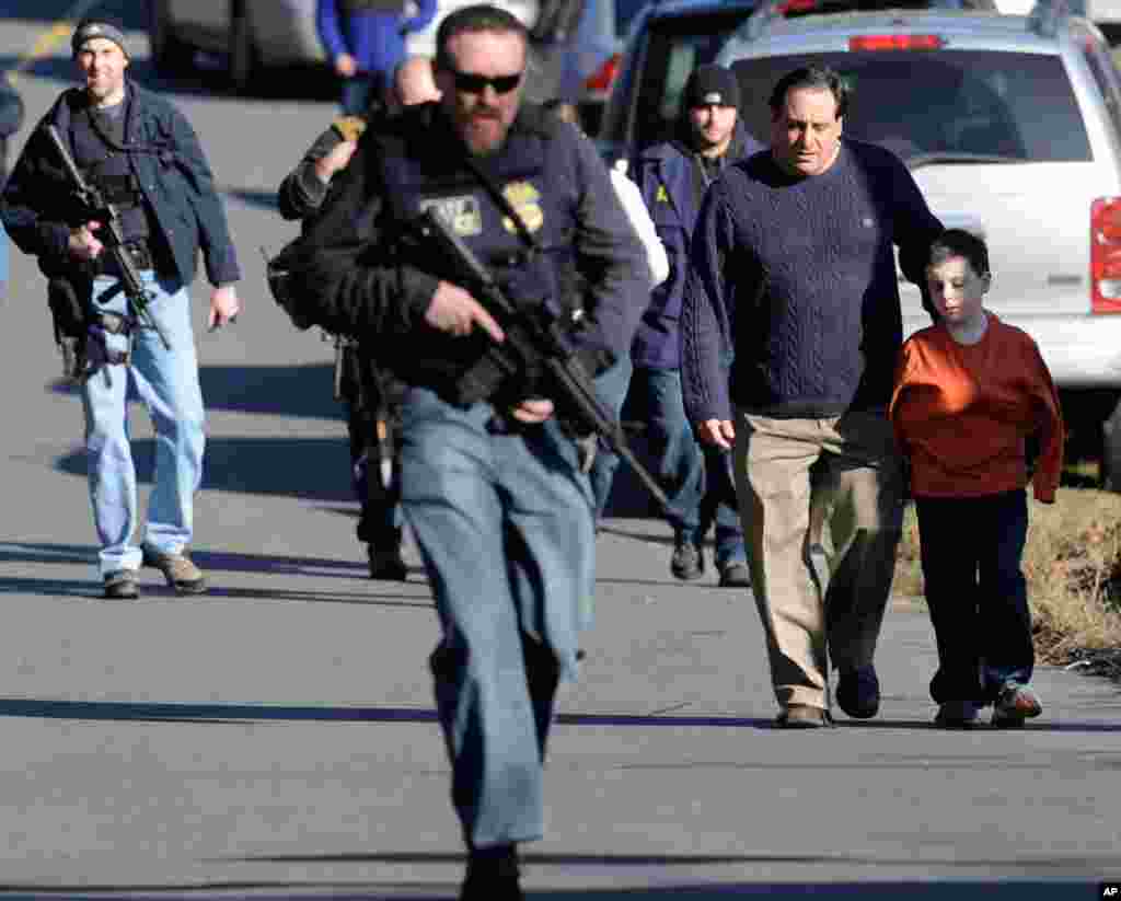 Parents leave a staging area after being reunited with their children following a shooting at the Sandy Hook Elementary School.