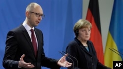 Thủ tướng Đức Angela Merkel (phải) và Thủ tướng Ukraine Arseniy Yatsenyuk nói chuyện trong cuộc họp báo tại dinh Thủ tướng ở Berlin, Đức, 8/1/15