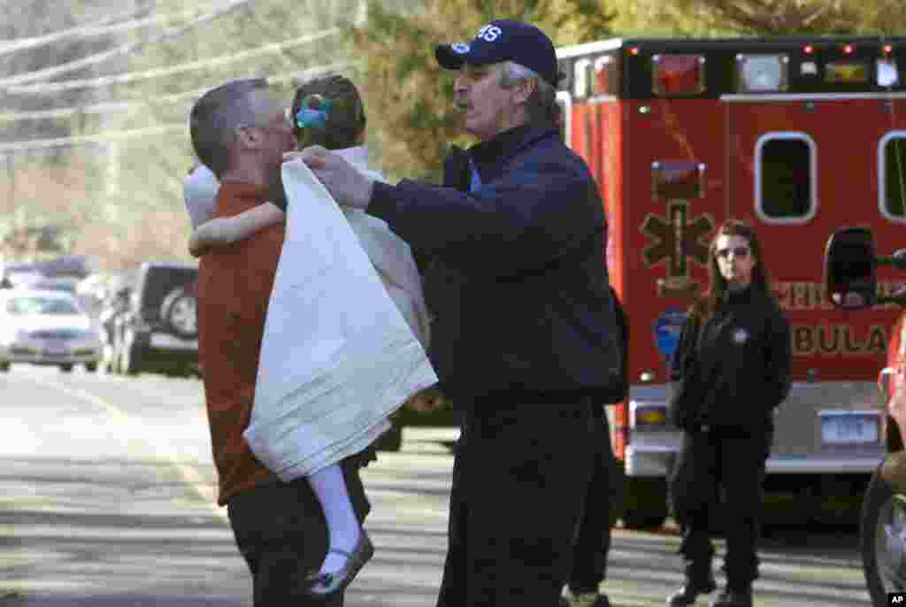 Một b&eacute; g&aacute;i được sơ t&aacute;n ra khỏi trường tiểu Sandy Hook sau vụ nổ s&uacute;ng, ng&agrave;y 14/12/2012.