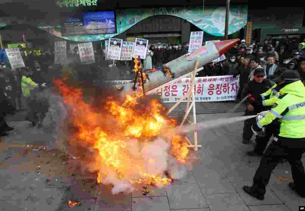 Tại một buổi tụ tập ở Seoul, người biểu t&igrave;nh Nam Triều Ti&ecirc;n đốt một t&ecirc;n lửa giả, khiến cảnh s&aacute;t phải d&ugrave;ng b&igrave;nh chữa ch&aacute;y dập tắt. (AP Photo/Ahn Young-joon) 