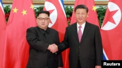 Lãnh tụ Bắc Hàn Kim Jong Un bắt tay với Chủ tịch Trung Quốc Tập Cận Bình tại Đại Liên, Trung Quốc. 