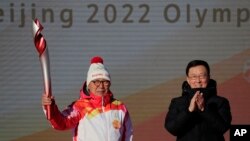 Premye atlet Chinwa kap pote toch olenpik la, Luo Zhihuan apre li sot resevwa li nan men Vis Premye Chinwa Han Zheng anvan rele toch la pou Jezolenpik Ive 2022 yo nan Peken, 2 Fevriye 2022. 