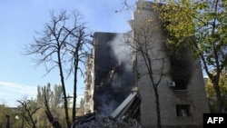 This photograph shows smoke rising from the debris of a residential building, heavily damaged following a recent strike, in the town of Lyman, Donetsk region, on October 24, 2024, amid the Russian invasion of Ukraine. (Photo by Genya SAVILOV / AFP)