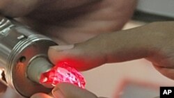 A staff member from the state-run Myanmar Gems Enterprise displays a 36 carat Ruby with a price tag of half a million Euros, on display at the Gems Emporium in Rangoon. (2006 file photo)