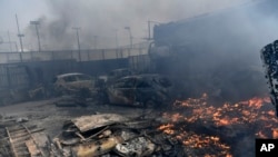 Atina'nın kuzeyinde terk edilmiş evler ve araçlar yangında kül oldu.