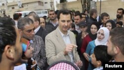 Tổng thống Syria Bashar al-Assad trò chuyện với cư dân trong chuyến thăm làng Ein al-Tinah, đông bắc Damascus, ngày 20/4/2014.