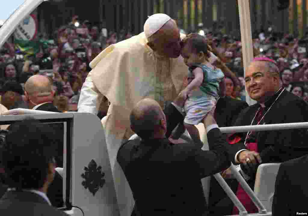 Ðức Giáo Hoàng hôn một em bé trong đám đông các tín đồ ở Rio de Janeiro, 22 tháng 7, 2013.