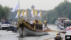 Ngọn đuốc Olympic đang được rước dọc theo sông Thames trên chiếc thuyền Gloriana của hoàng gia