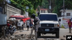 Police remove a roadblock set by protesters in Port-au-Prince, Haiti, Oct. 18, 2021. 