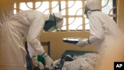 Bác sĩ Kent Brantly (trái) chữa trị cho bệnh nhân nhiễm virút Ebola ở Liberia.