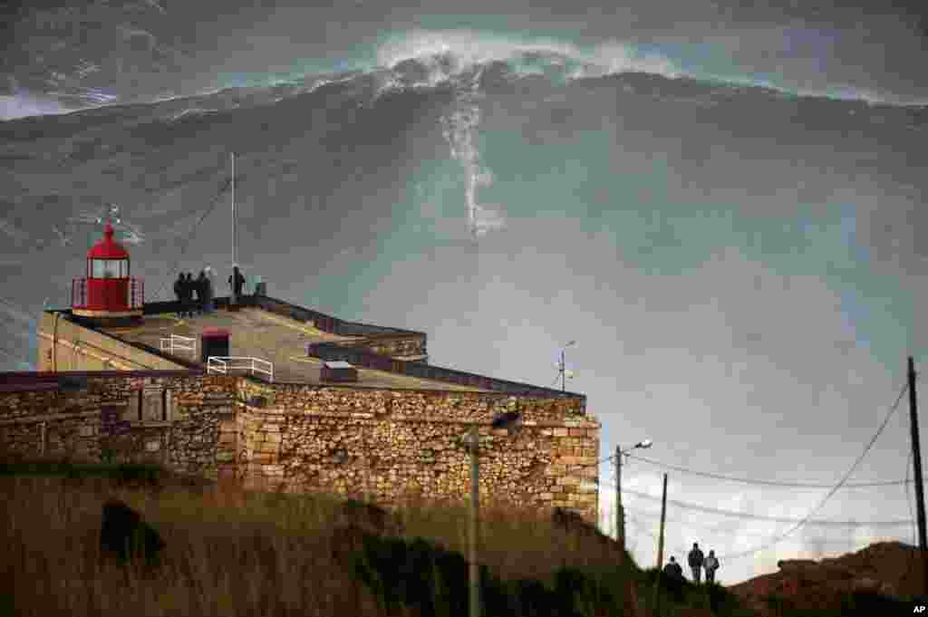 Ảnh chụp từ xa khi Garrett McNamara leo qua được ngọn s&oacute;ng hơn 30 m&eacute;t tại bờ biển Praia do Norte ở th&agrave;nh phố Nazare của Bồ Đ&agrave;o Nha.