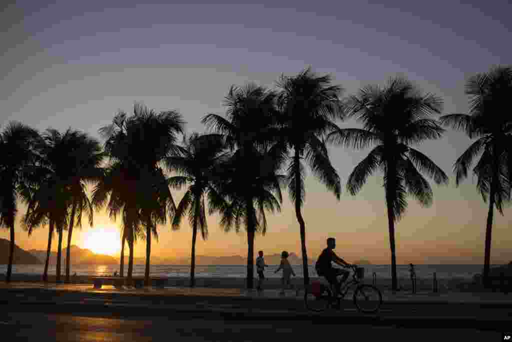 Người dân tập thể dục dọc theo bãi biển Copacabana vào lúc mặt trời mọc tại Rio de Janeiro, Brazil.