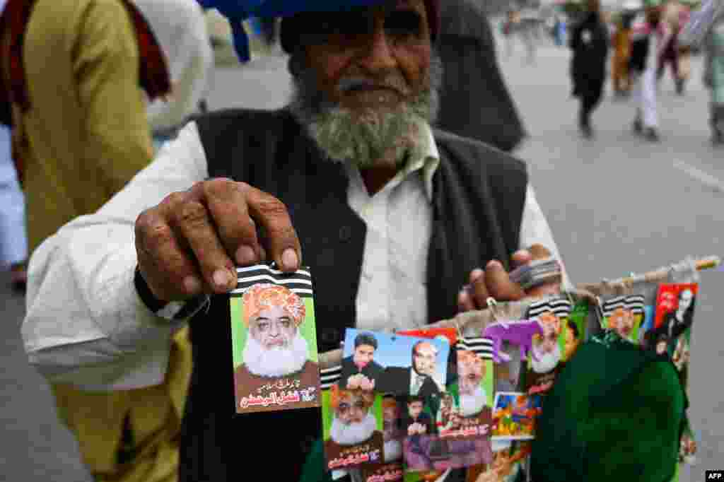 ایک بزرگ جلسے کے پنڈال میں مولانا فضل الرحمٰن کے بیجز اور اسٹیکرز فروخت کر رہے ہیں۔