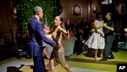 Arjantin'de tango yapmak için dansa kaldırılan Başkan Obama ve eşi Michelle (arkada)