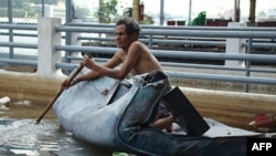 Một nạn nhân lụt trên tấm nệm chèo dọc theo sông Chao Phraya River ở Bangkok, Thái Lan, Ngày 3 tháng 11, 2011