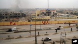 Xe cộ bị đốt và các tòa nhà bị hư hại ở Fallujah, 65 km về phía tây của Baghdad, Iraq, 3/1/2014