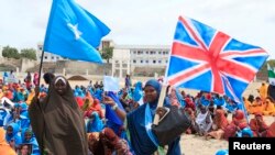 Cư dân phất cờ Anh và Somalia tham gia cuộc diễu hành tại thủ đô Somalia ủng hộ hội nghị Somalia ở London, ngày 7/5/2013.