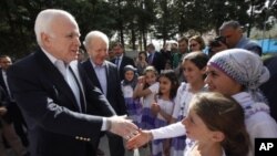 Thượng nghị sĩ Mỹ John McCain (trái) và Joseph Lieberman được các trẻ em tị nạn Syria chào đón trong chuyến thăm của họ đến trại tị nạn Yayladagi ở biên giới Thổ Nhĩ Kỳ-Syria, 10/4/2012