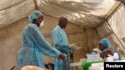 Các nhân viên y tế lấy máu xét nghiệm virus Ebola tại một căn lều khám bệnh ở Kenema, Sierra Leone. 